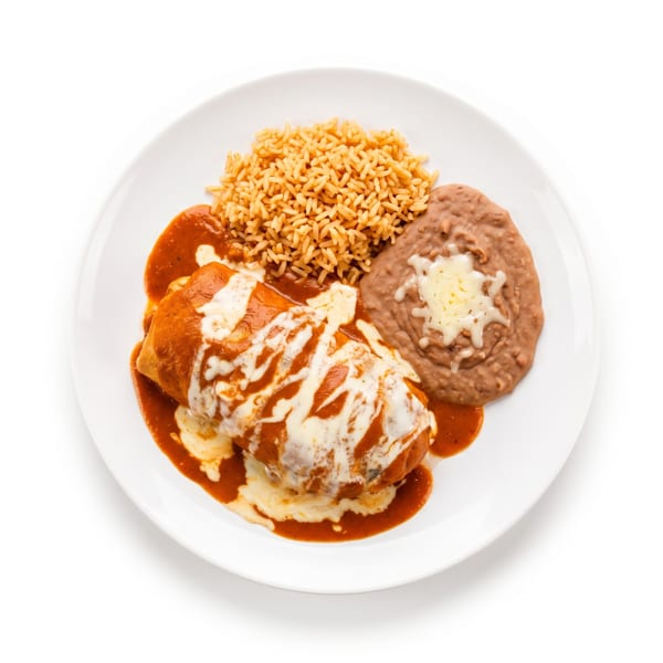 A white plate holds a burrito covered in red sauce and cheese, with rice and refried beans.
