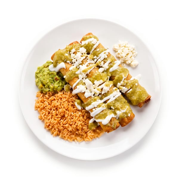 Three taquitos topped with green sauce, sour cream, and cheese, served with rice and guacamole.